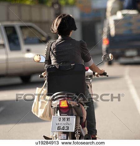 Stock Image - Woman riding a motorcycle, Chiang Mai, Thailand. Fotosearch