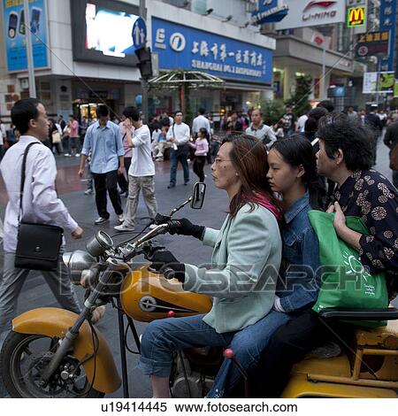 Woman riding a motorcycle, Shanghai, China View Large Photo Image Stock Photography - Woman riding a motorcycle, Shanghai, China. Fotosearch