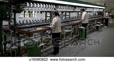 Stock Image - Workers in a silk factory, Suzhou, Jiangsu Province, China. Fotosearch