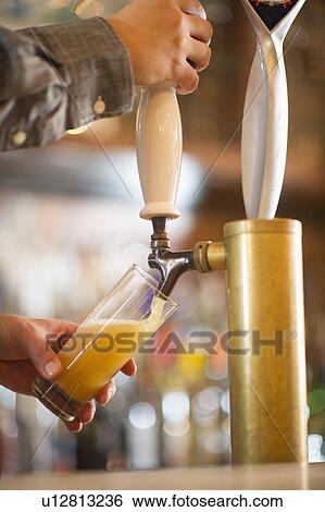 Barman poring beer from beer tap View Large Photo Image Stock Photograph - Barman poring beer from beer tap . Fotosearch