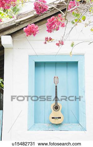 Stock Image - Brazil, Bahia, Trancoso, Guitar against building wall. Fotosearch