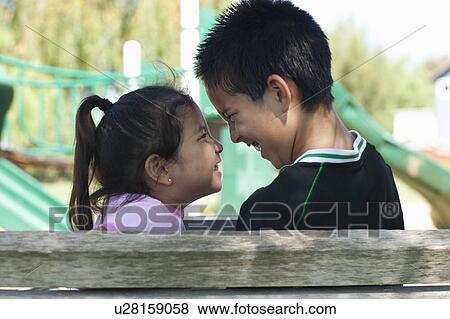 Brother and sister (4-13) face to face at playground View Large Photo Image Stock Photo - Brother and sister (4-13) face to face at playground. Fotosearch