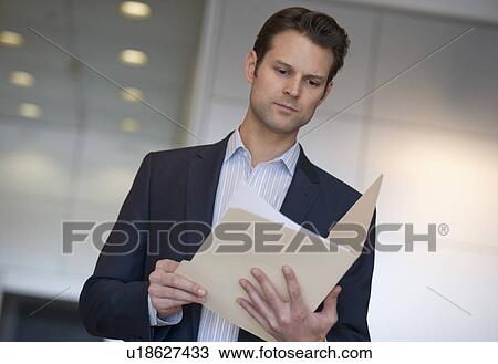 Stock Image - Businessman reading documents. Fotosearch