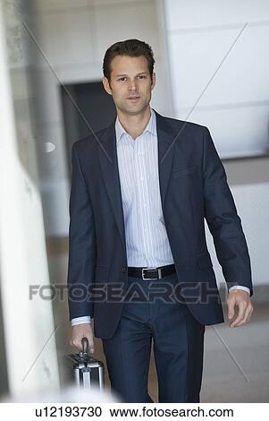 Businessman walking down hallway View Large Photo Image Stock Image - Businessman walking down hallway. Fotosearch