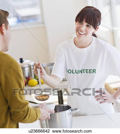 Charity volunteer handing out free soup View Large Photo Image Stock Image - Charity volunteer handing out free soup. Fotosearch