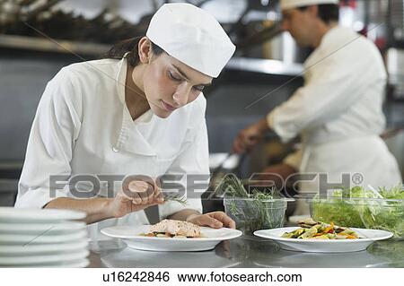 Chef and cook preparing food in commercial kitchen View Large Photo Image Stock Photograph - Chef and cook preparing food in commercial kitchen. Fotosearch