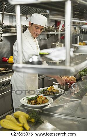 Stock Photography - Chef preparing food in kitchen. Fotosearch