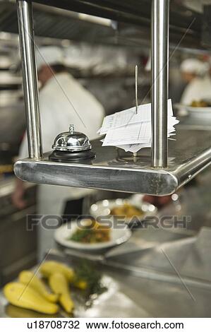 Chefs preparing food in kitchen, focus on service bell on foreground View Large Photo Image Stock Image - Chefs preparing food in kitchen, focus on service bell on foreground. Fotosearch
