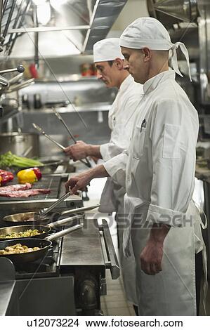 Chefs preparing food in kitchen View Large Photo Image Picture - Chefs preparing food in kitchen. Fotosearch