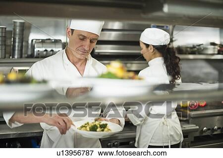 Chefs preparing food in kitchen View Large Photo Image Stock Photo - Chefs preparing food in kitchen. Fotosearch