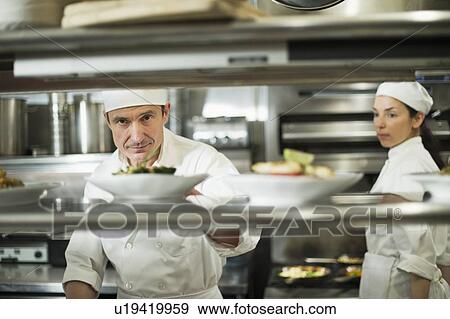 Chefs preparing food in kitchen View Large Photo Image Stock Photo - Chefs preparing food in kitchen. Fotosearch