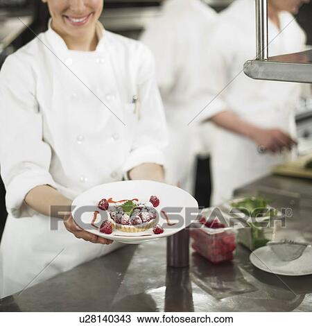 Chefs preparing food in kitchen, women showing dessert View Large Photo Image Stock Image - Chefs preparing food in kitchen, women showing dessert. Fotosearch