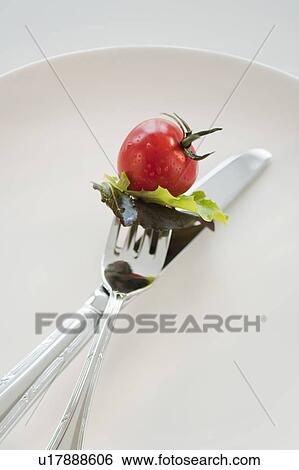 Cherry tomato and lettuce leaves on fork View Large Photo Image Stock Photograph - Cherry tomato and lettuce leaves on fork. Fotosearch