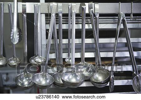 Stock Image - Close up ladles in commercial kitchen. Fotosearch