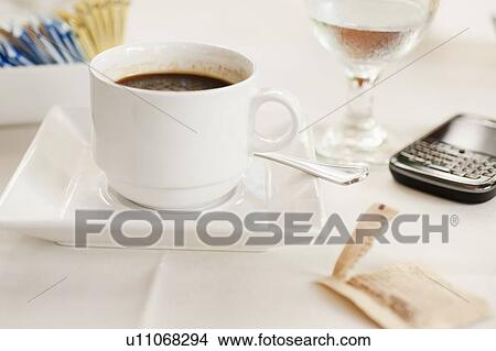 Picture - Close up of coffee cup and pda on table. Fotosearch