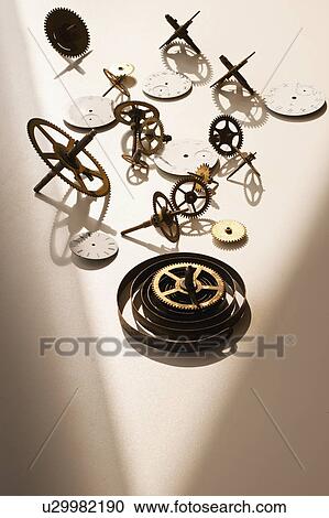 Stock Image - Close up of gears and clock parts on white background. Fotosearch