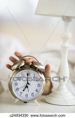 Close-up of man's hand reaching to alarm clock from bed View Large Photo Image Stock Image - Close-up of man's hand reaching to alarm clock from bed. Fotosearch
