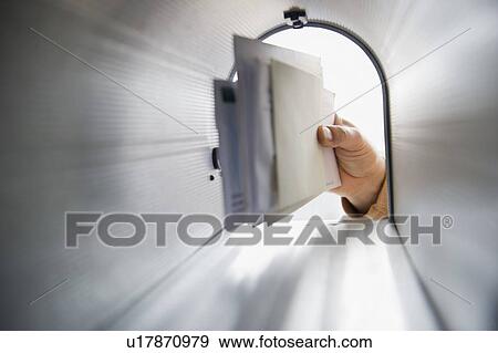Stock Photo - Close-up of man's hand removing letters from letter box. Fotosearch