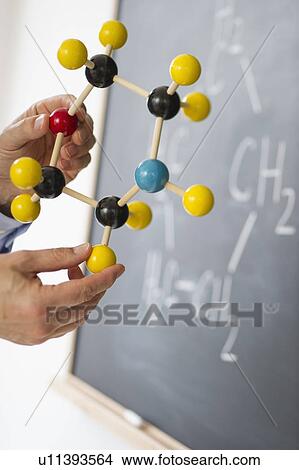 Close-up of man's hands holding molecule model, blackboard in background View Large Photo Image Picture - Close-up of man's hands holding molecule model, blackboard in background. Fotosearch