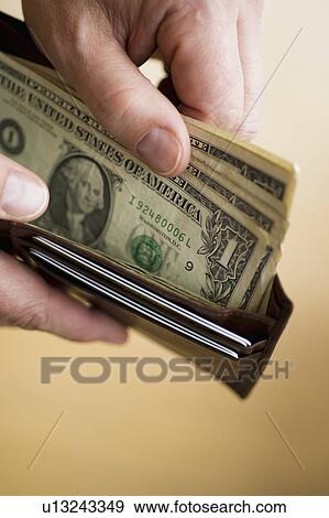Close-up of man's hands holding wallet with dollar banknotes View Large Photo Image Stock Photo - Close-up of man's hands holding wallet with dollar banknotes. Fotosearch