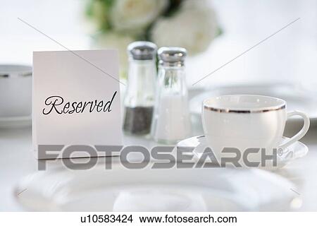 Picture - Close up of place setting with reserved sign. Fotosearch