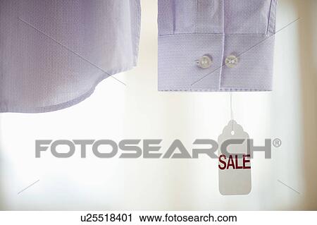 Stock Image - Close up of shirt cuff with sale tag. Fotosearch