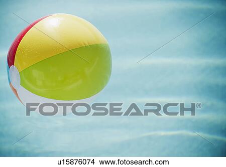 Picture - Close up of striped beach ball against water surface. Fotosearch