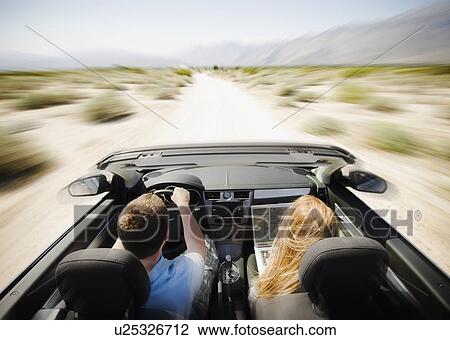 Couple driving through desert in convertible car View Large Photo Image Stock Image - Couple driving through desert in convertible car. Fotosearch