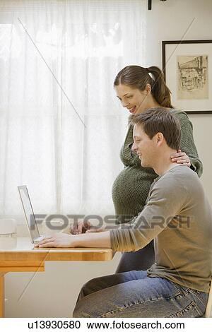 Couple using laptop at home View Large Photo Image Stock Image - Couple using laptop at home. Fotosearch