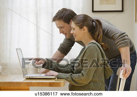Stock Photo - Couple using laptop at home. Fotosearch