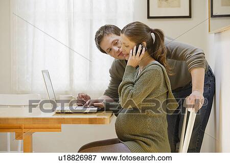 Stock Photo - Couple using laptop at home. Fotosearch