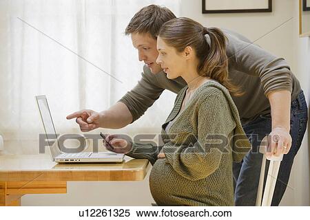 Couple using laptop at home View Large Photo Image Stock Photography - Couple using laptop at home. Fotosearch