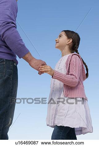 Stock Photo - Daughter (8-9) and father holding hands. Fotosearch