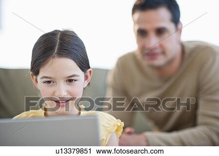 Daughter (8-9) and father using laptop View Large Photo Image Stock Image - Daughter (8-9) and father using laptop . Fotosearch