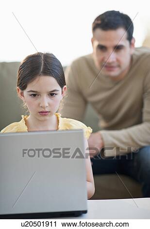 Daughter (8-9) and father using laptop View Large Photo Image Stock Image - Daughter (8-9) and father using laptop . Fotosearch