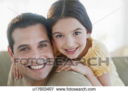 Stock Photo - Daughter (8-9) embracing father. Fotosearch