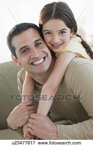 Stock Photo - Daughter (8-9) embracing father. Fotosearch