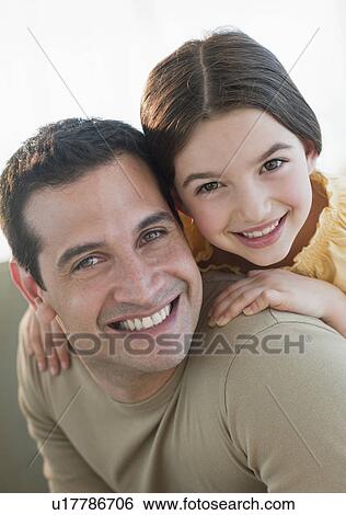Stock Photograph - Daughter (8-9) embracing father. Fotosearch