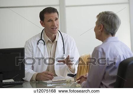 Stock Photo - Doctor and female patient sitting in office. Fotosearch