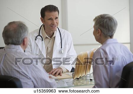 Doctor and senior couple talking in office View Large Photo Image Stock Image - Doctor and senior couple talking in office. Fotosearch