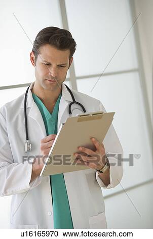 Stock Image - Doctor filling medical documents. Fotosearch