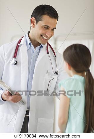 Doctor talking to girl (8-9) View Large Photo Image Picture - Doctor talking to girl (8-9). Fotosearch
