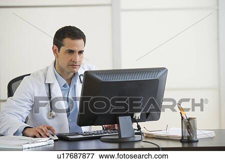 Doctor using computer in office View Large Photo Image Stock Photo - Doctor using computer in office. Fotosearch