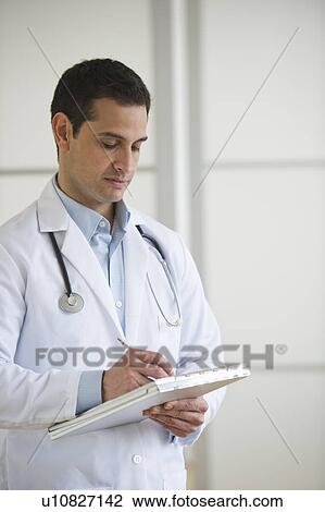 Doctor writing in notepad View Large Photo Image Stock Image - Doctor writing in notepad. Fotosearch