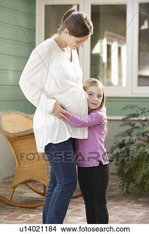 Expectant mother embracing daughter (4-5) View Large Photo Image Picture - Expectant mother embracing daughter (4-5). Fotosearch