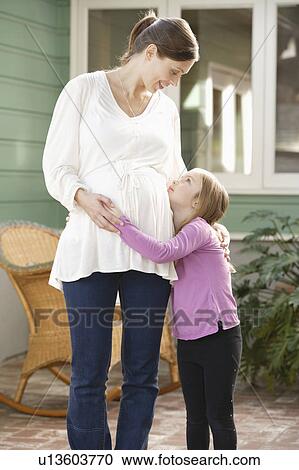 Stock Image - Expectant mother embracing daughter (4-5). Fotosearch