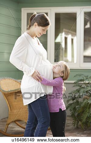 Stock Photo - Expectant mother embracing daughter (4-5). Fotosearch