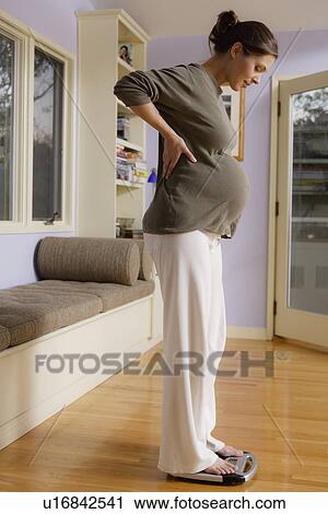 Expectant mother using bathroom scales View Large Photo Image Stock Image - Expectant mother using bathroom scales. Fotosearch