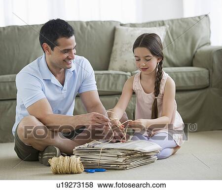 Father and daughter (8-9) wrapping up wastepaper bundle View Large Photo Image Stock Photo - Father and daughter (8-9) wrapping up wastepaper bundle. Fotosearch