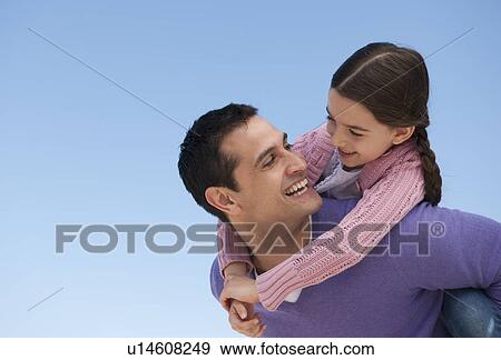 Stock Photo - Father giving piggyback ride to daughter (8-9). Fotosearch